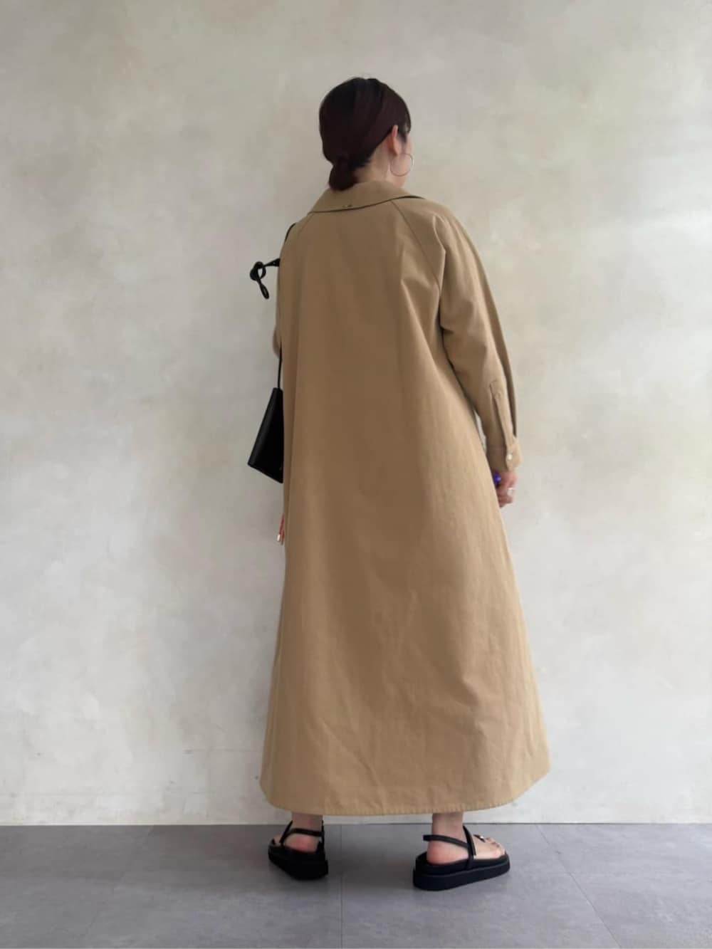 ブラック系のサンダル、ブラック系のショルダーバッグ、ベージュ系のワンピースを着用したレディースの春コーディネートの5枚目の写真