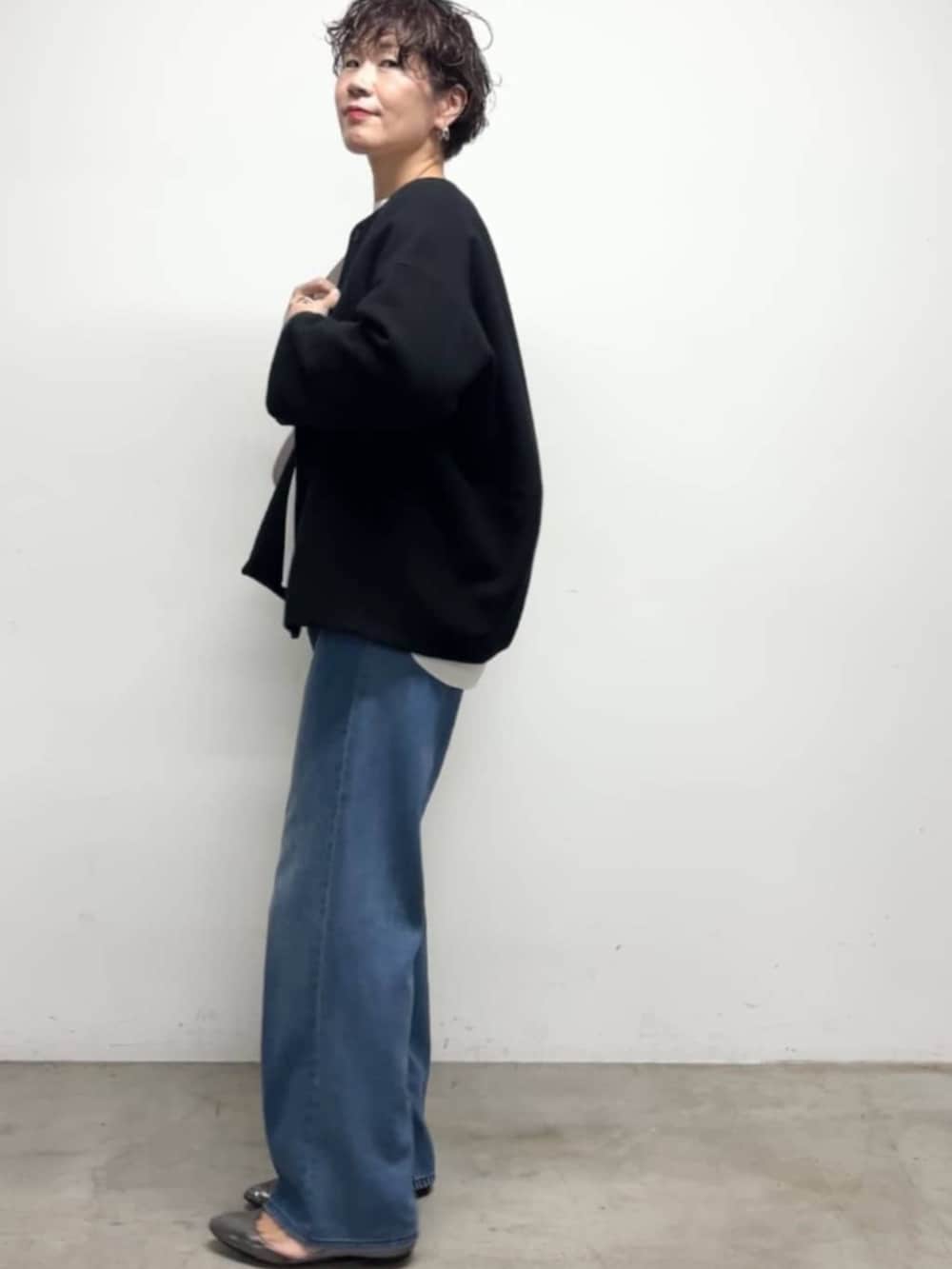 ブルー系のデニムパンツ、ブルー系のノーカラーコート、ホワイト系のシャツ/ブラウスを着用したレディースの冬コーディネートの4枚目の写真