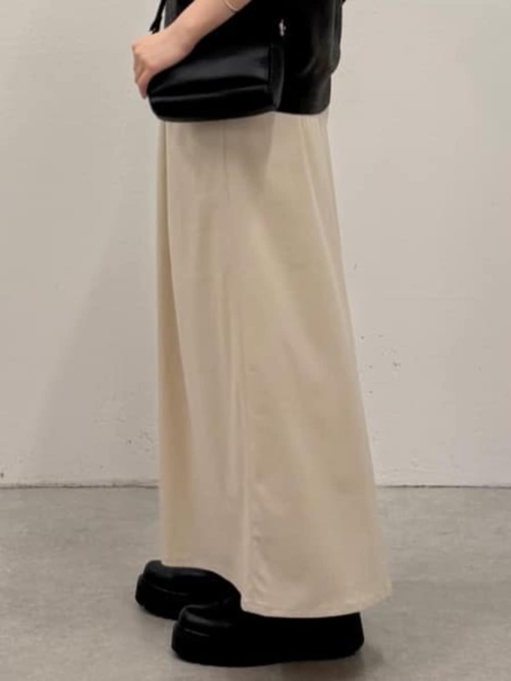 ベージュ系のスカート、グレー系のニット/セーターを着用したレディースの夏コーディネートの5枚目の写真