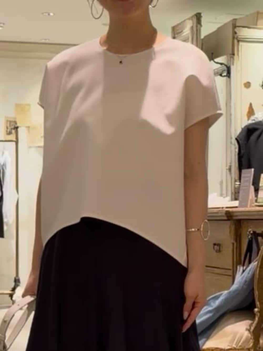 ホワイト系のトートバッグ、ホワイト系のシャツ/ブラウス、ブラック系のスカートを着用したレディースの春コーディネートの3枚目の写真