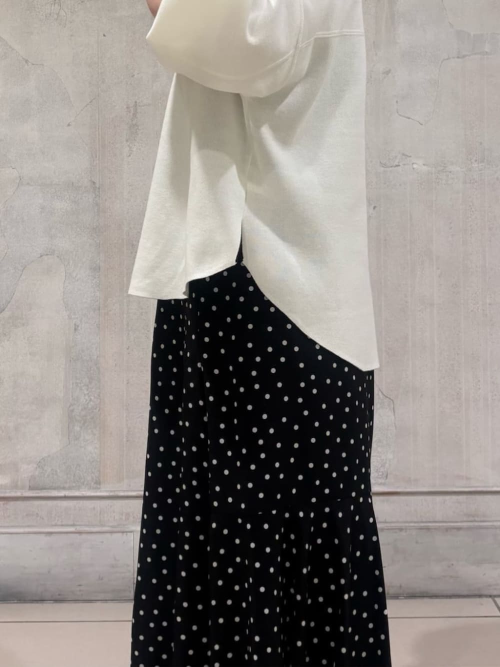 ブラック系のハンドバッグ、ブラック系のスカート、ホワイト系のTシャツ/カットソーを着用したレディースの春コーディネートの8枚目の写真