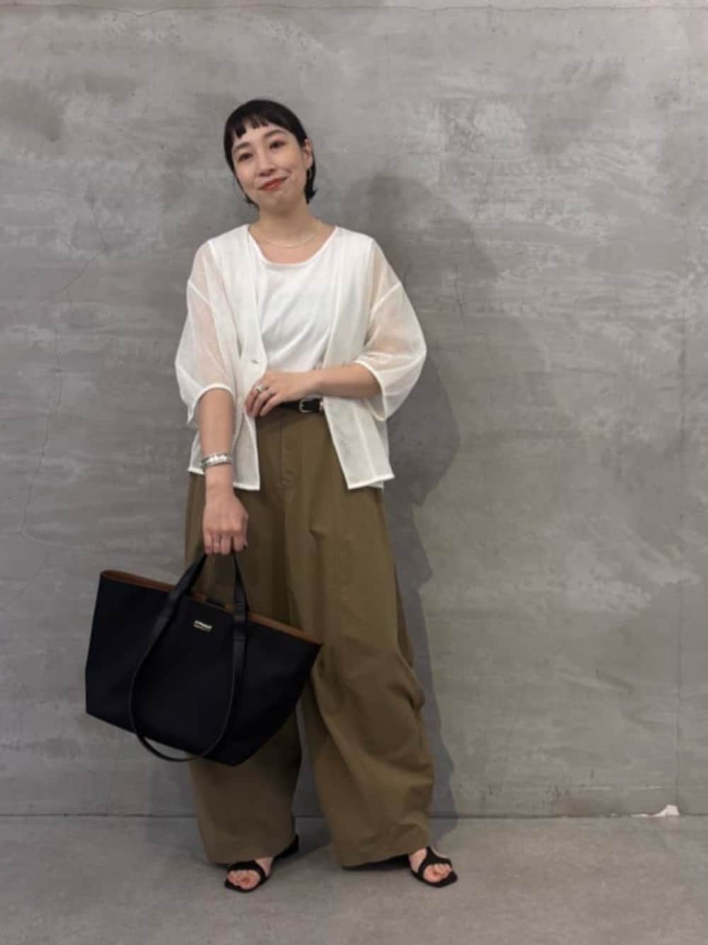 イエロー系のその他パンツ、ホワイト系のシャツ/ブラウス、ブラック系のトートバッグを着用したレディースの春コーディネートの2枚目の写真