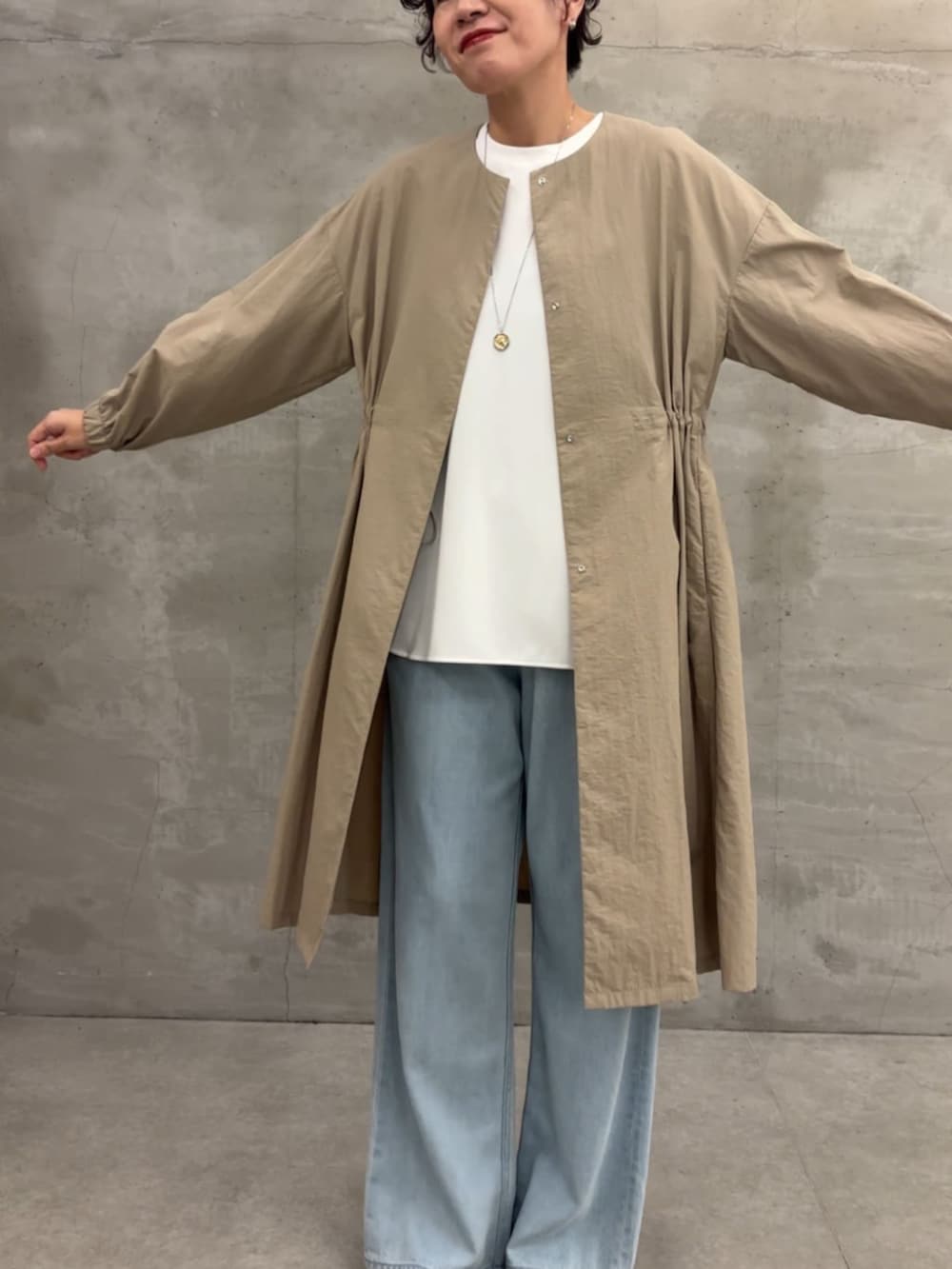 ベージュ系のその他アウター、ブラック系のボストンバッグ、ブルー系のデニムパンツを着用したレディースの冬コーディネートの5枚目の写真