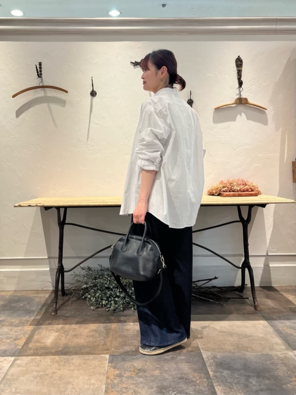 ブラック系のボストンバッグ、ブルー系のその他パンツ、ホワイト系のシャツ/ブラウスを着用したレディースの冬コーディネートの3枚目の写真