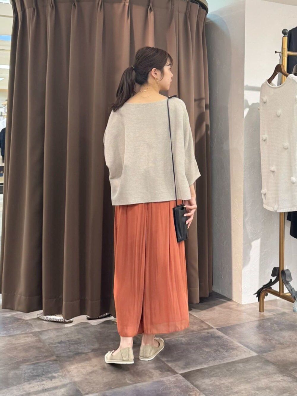 オレンジ系のその他パンツ、ベージュ系のニット/セーターを着用したレディースの春コーディネートの3枚目の写真