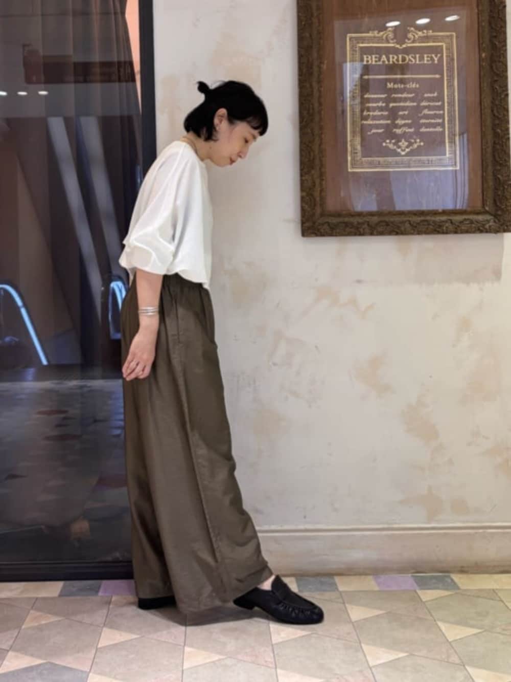 グリーン系のその他パンツ、ブラック系のその他シューズ、ホワイト系のTシャツ/カットソーを着用したレディースの夏コーディネートの3枚目の写真
