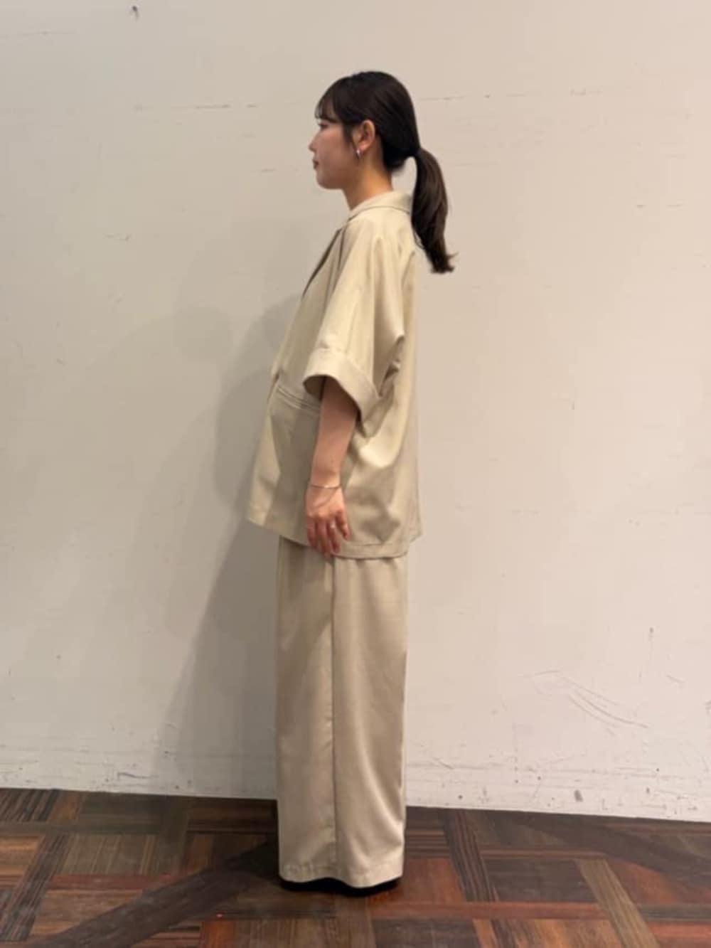 ベージュ系のテーラードジャケット、ベージュ系のその他パンツ、ホワイト系のシャツ/ブラウスを着用したレディースの春コーディネートの2枚目の写真