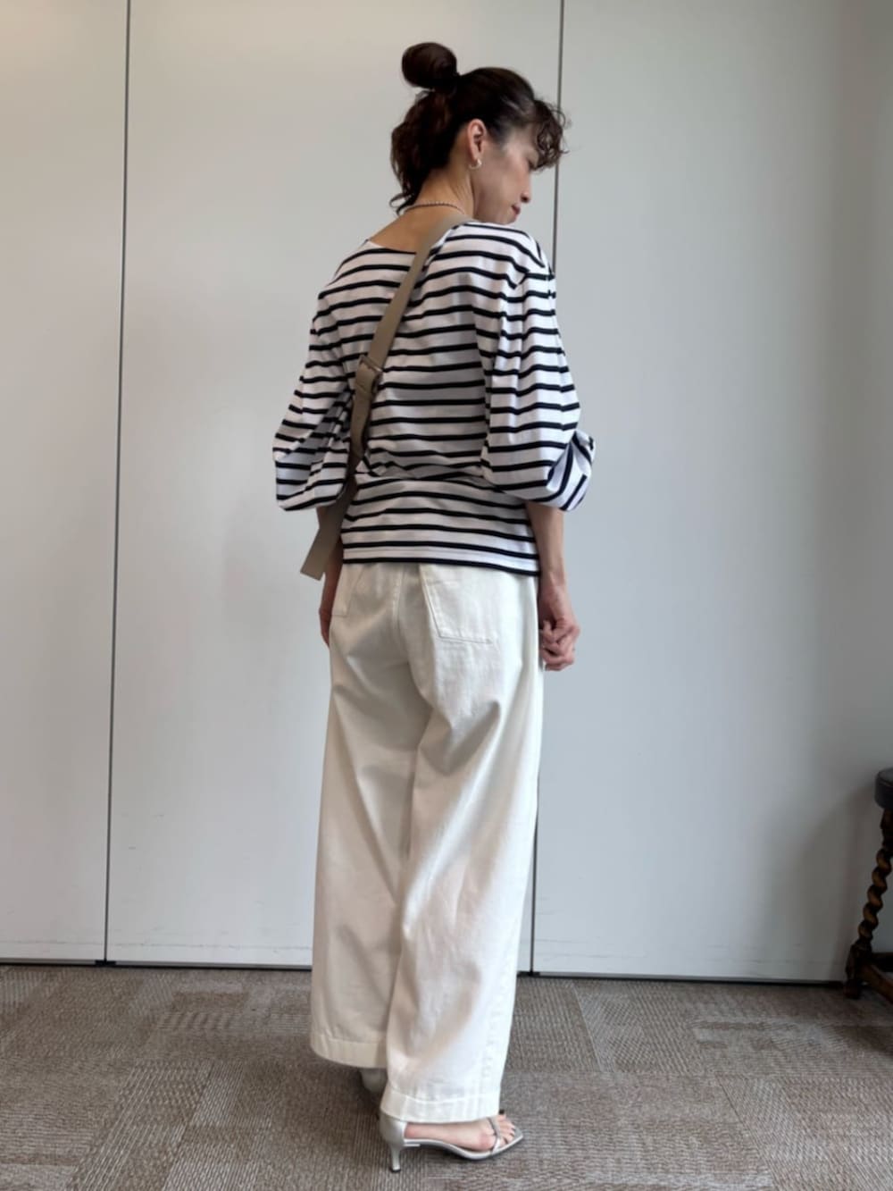 ベージュ系のショルダーバッグ、ホワイト系のTシャツ/カットソーを着用したレディースの冬コーディネートの2枚目の写真