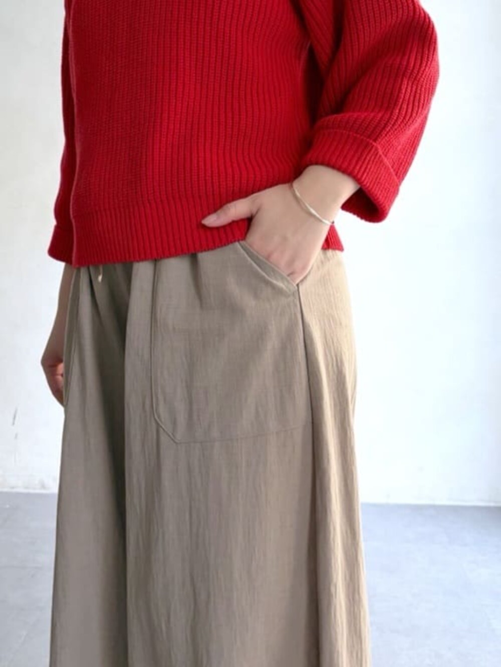 ベージュ系のその他パンツ、レッド系のニット/セーターを着用したレディースの冬コーディネートの5枚目の写真