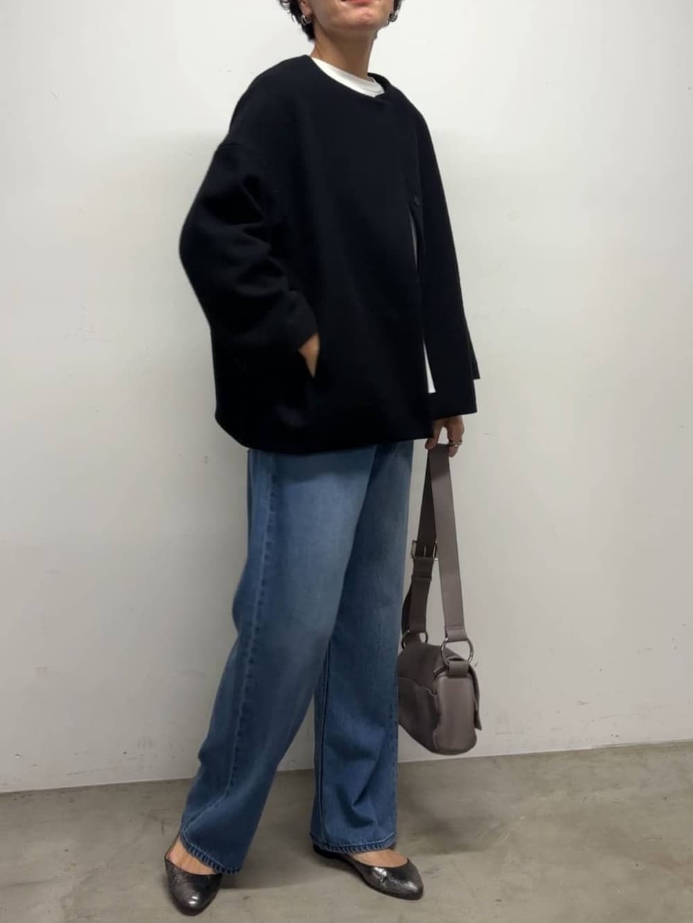 ブルー系のデニムパンツ、ブルー系のノーカラーコート、ホワイト系のシャツ/ブラウスを着用したレディースの冬コーディネートの2枚目の写真