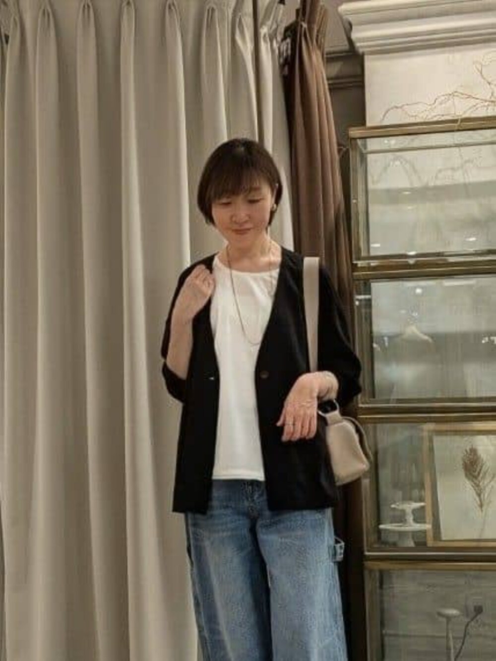 ホワイト系のタンクトップ、ベージュ系のショルダーバッグ、ブルー系のその他パンツを着用したレディースの春コーディネートの5枚目の写真