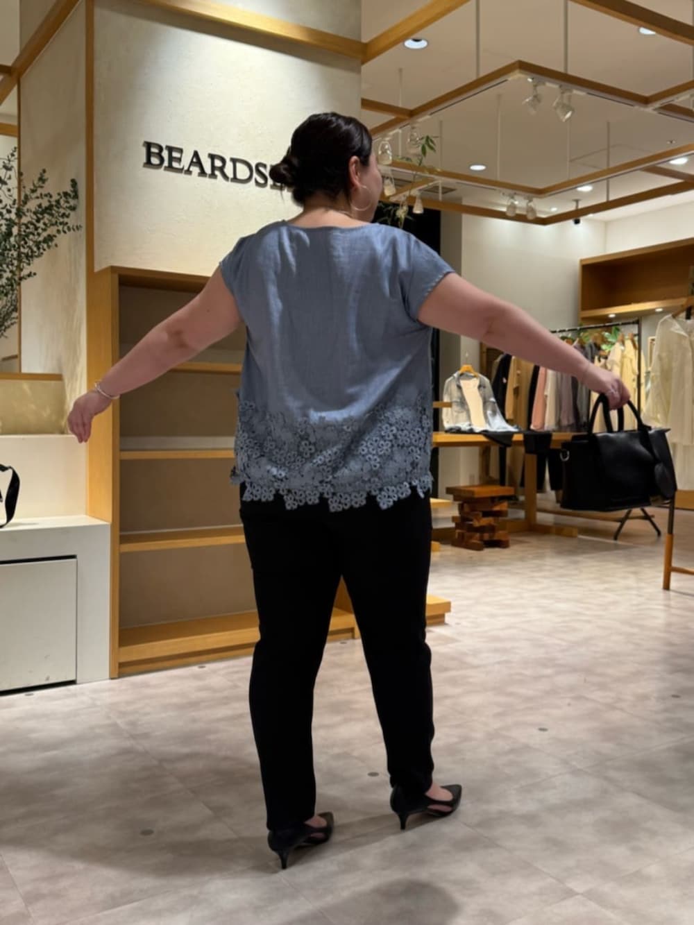 ブラック系のハンドバッグ、ブルー系のシャツ/ブラウス、ブラック系のその他パンツを着用したレディースの春コーディネートの6枚目の写真