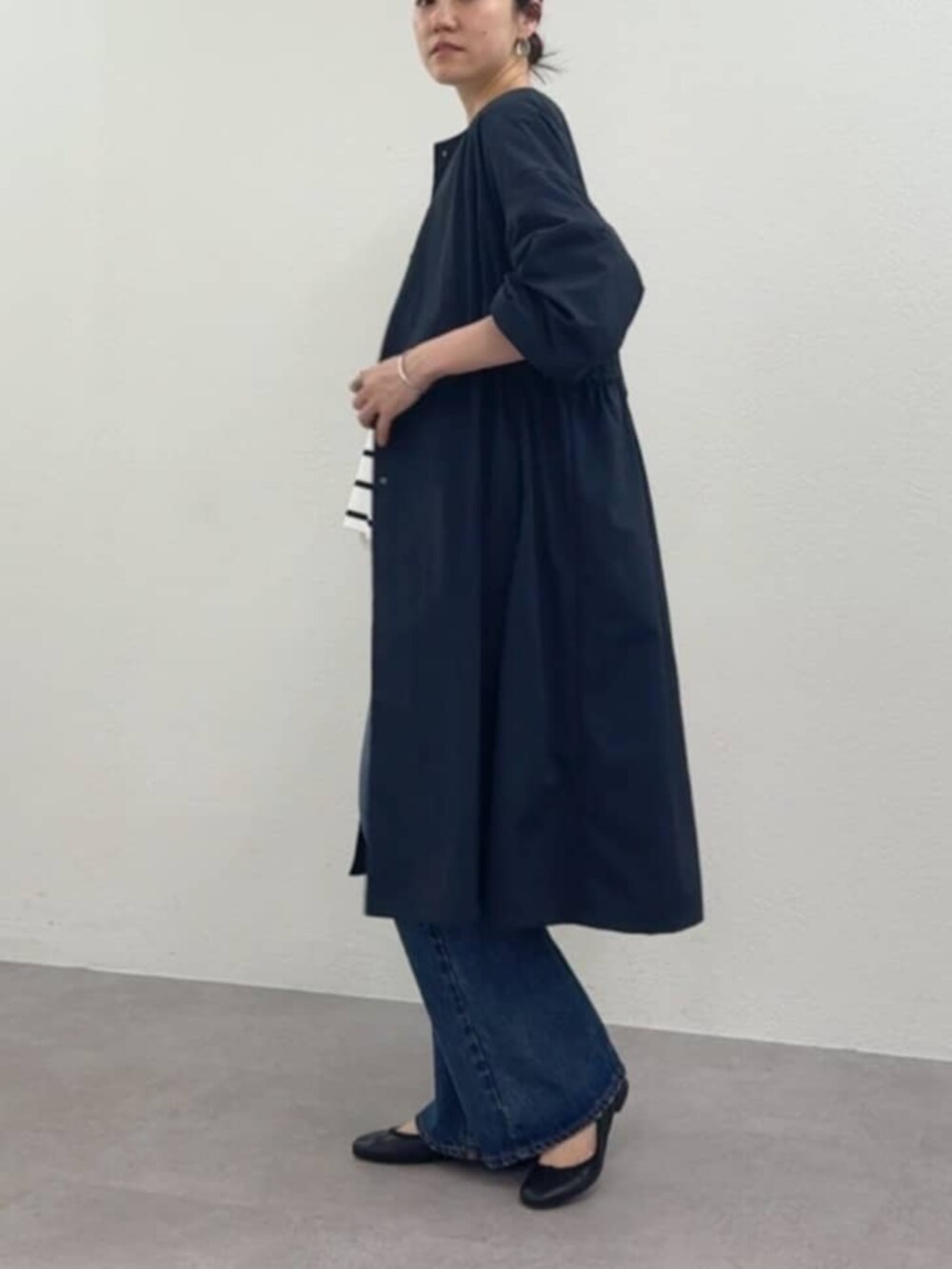 グレー系のハンドバッグ、ホワイト系のタンクトップ、ブルー系のその他アウターを着用したレディースの冬コーディネートの3枚目の写真