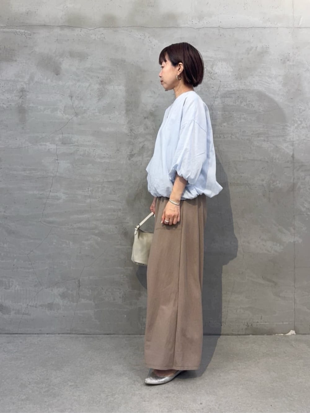 ベージュ系のその他パンツ、ホワイト系のトートバッグ、ブルー系のシャツ/ブラウスを着用したレディースの冬コーディネートの3枚目の写真