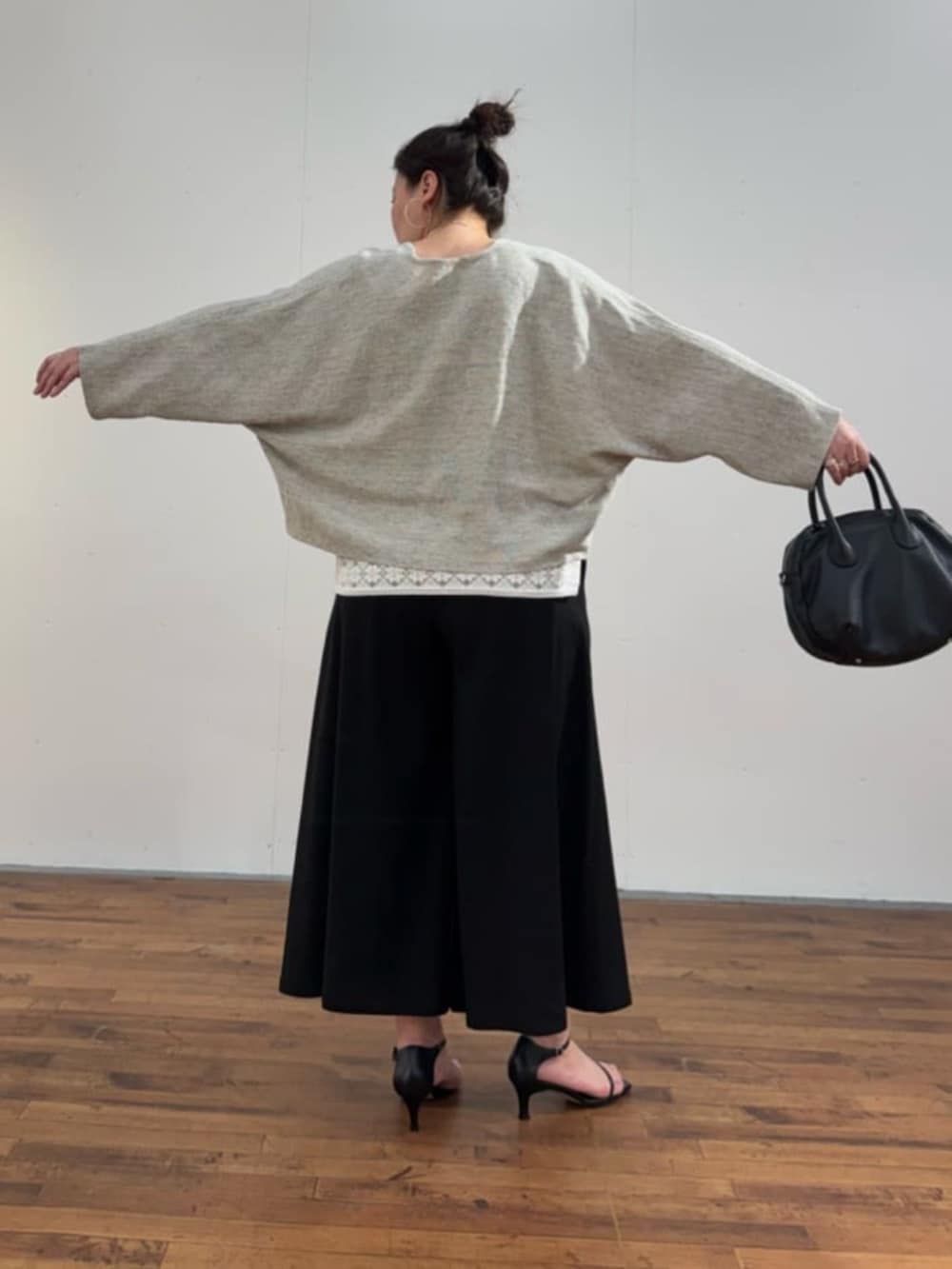 ブラック系のボストンバッグ、ホワイト系のシャツ/ブラウス、グレー系のカーディガン/ボレロを着用したレディースの春コーディネートの8枚目の写真