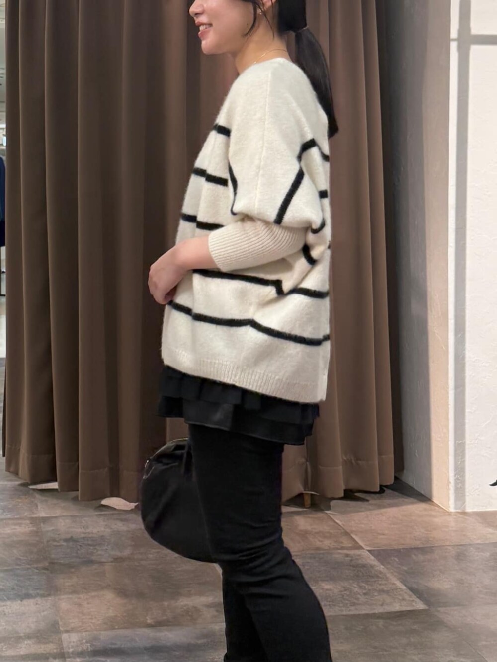 ブラック系のその他パンツ、ホワイト系のニット/セーター、ブラック系のタンクトップを着用したレディースの冬コーディネートの5枚目の写真