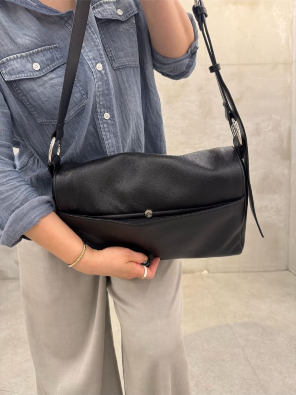 ブルー系のシャツ/ブラウス、ブラック系のショルダーバッグを着用したレディースの春コーディネートの6枚目の写真