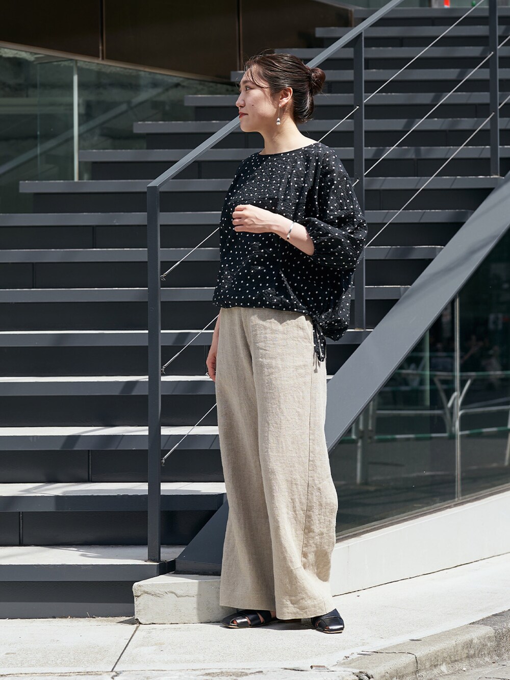 ブラック系のシャツ/ブラウス、ベージュ系のその他パンツを着用したレディースの夏コーディネートの2枚目の写真