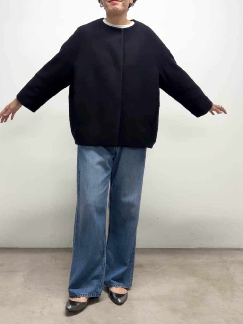 ブルー系のデニムパンツ、ブルー系のノーカラーコート、ホワイト系のシャツ/ブラウスを着用したレディースの冬コーディネートの6枚目の写真