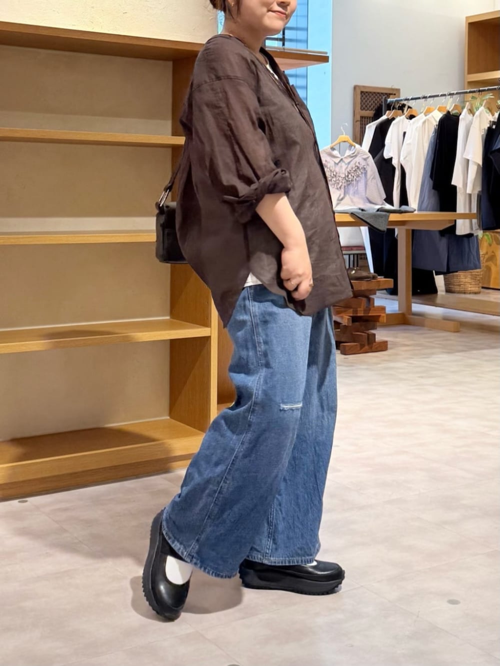 ブルー系のその他パンツ、ブラック系のスニーカー、ブラウン系のシャツ/ブラウスを着用したレディースの春コーディネートの6枚目の写真