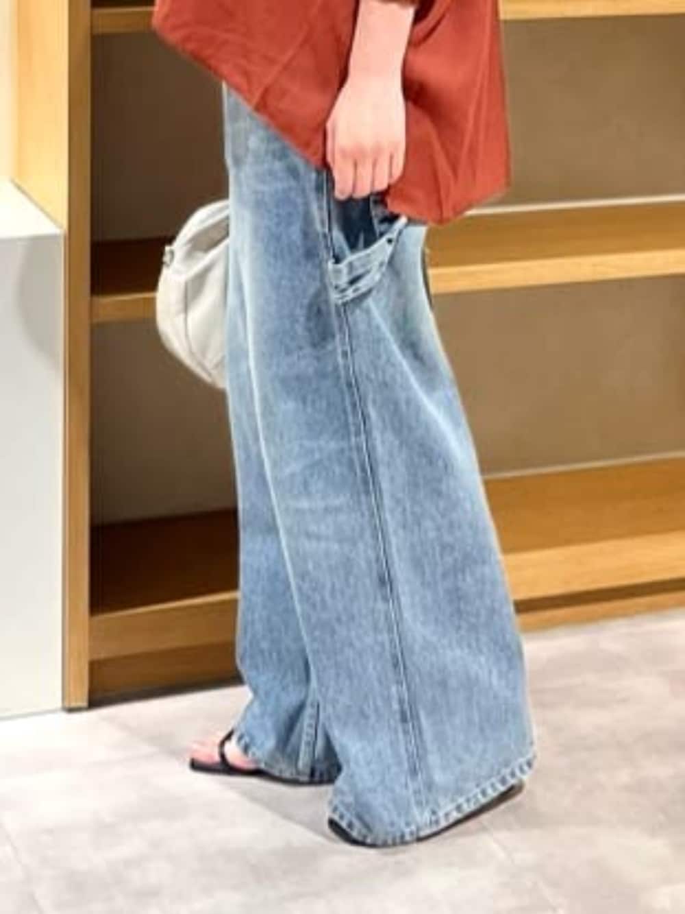 レッド系のシャツ/ブラウス、ブルー系のデニムパンツを着用したレディースの夏コーディネートの4枚目の写真