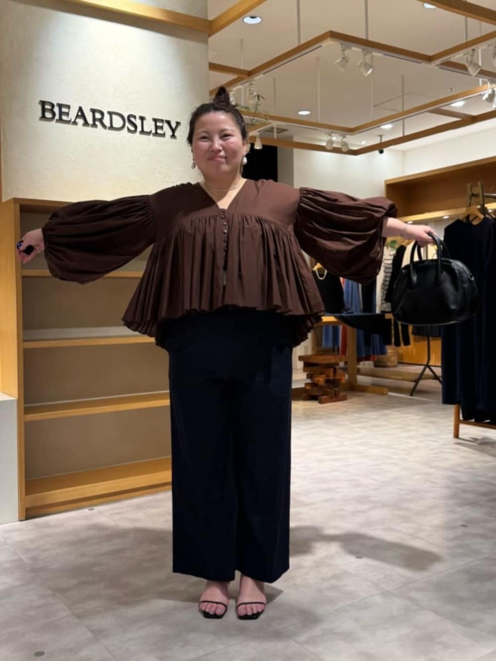 ブラック系のボストンバッグ、ブルー系のその他パンツ、ブラウン系のシャツ/ブラウスを着用したレディースの冬コーディネートの3枚目の写真