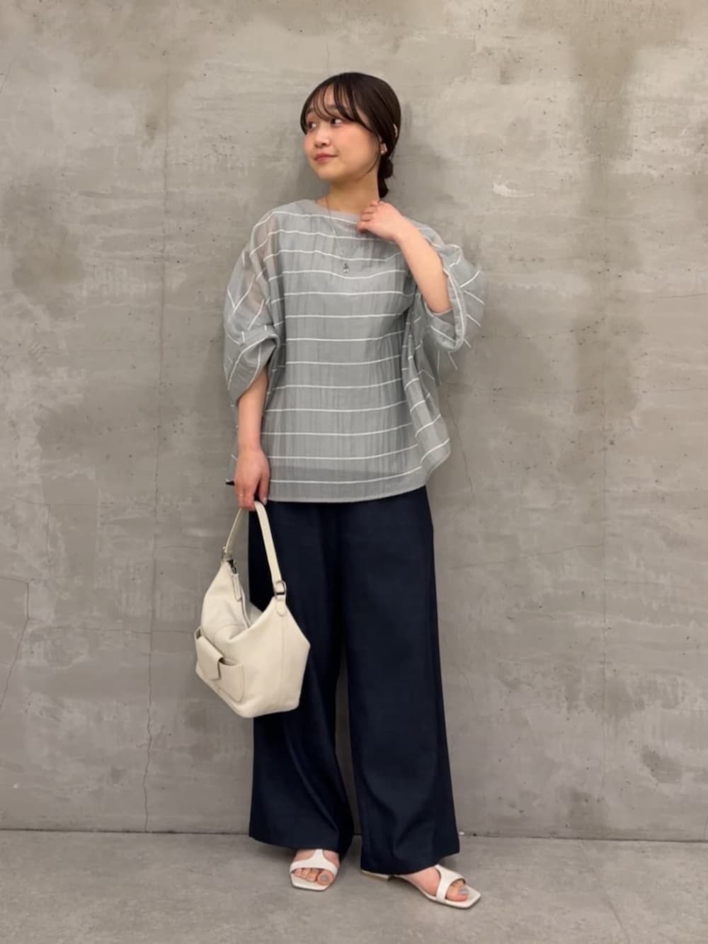 ブルー系のその他パンツ、ホワイト系のトートバッグ、グレー系のシャツ/ブラウスを着用したレディースの春コーディネートの3枚目の写真