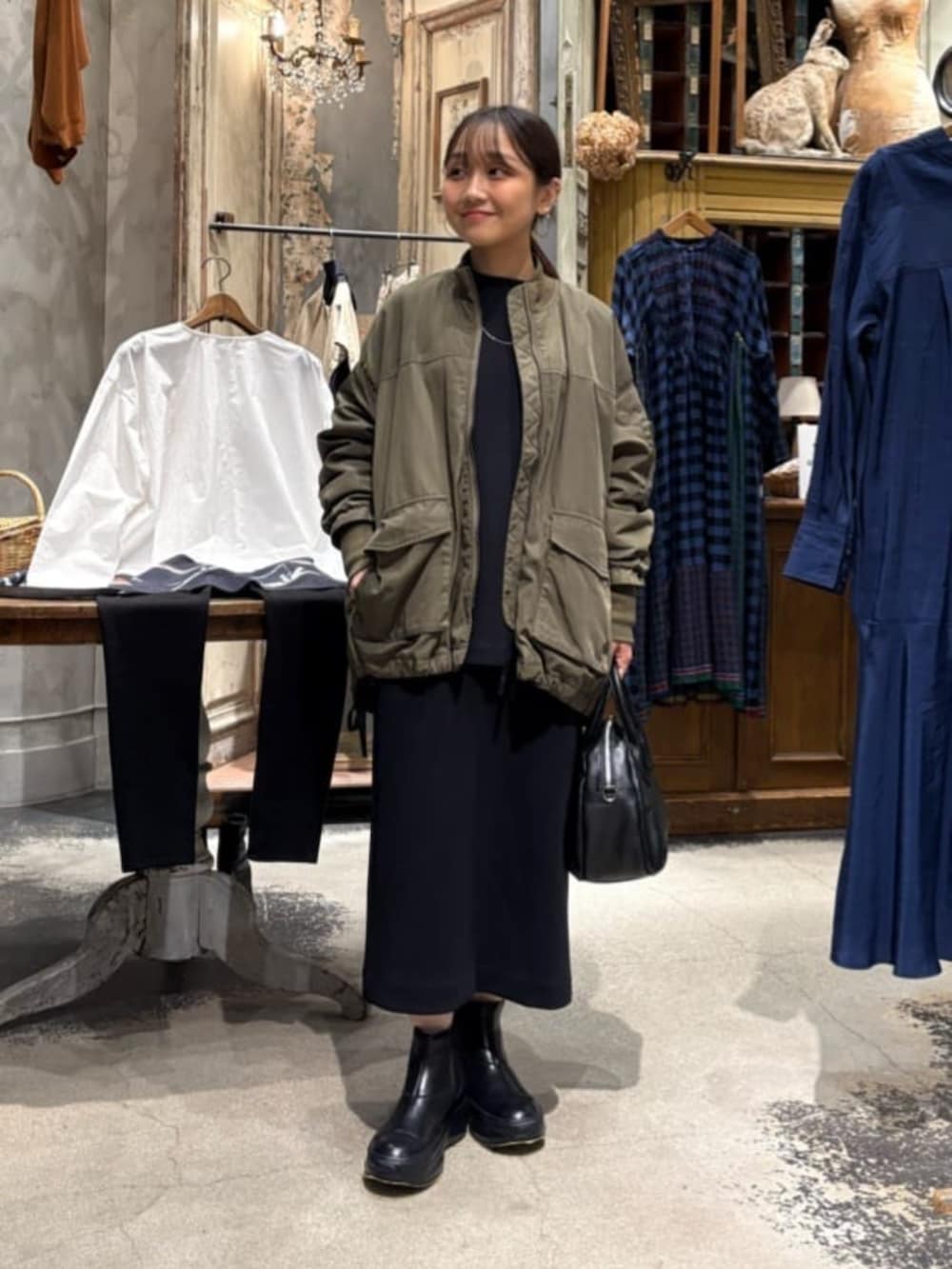 グリーン系のMA-1、ブラック系のスカートを着用したレディースの冬コーディネートの5枚目の写真