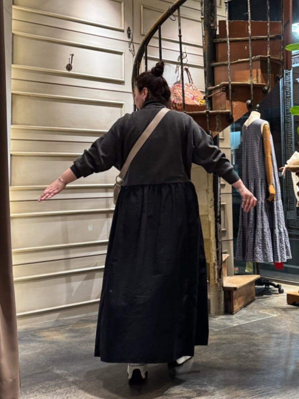 グレー系のワンピース、ベージュ系のショルダーバッグを着用したレディースの冬コーディネートの4枚目の写真