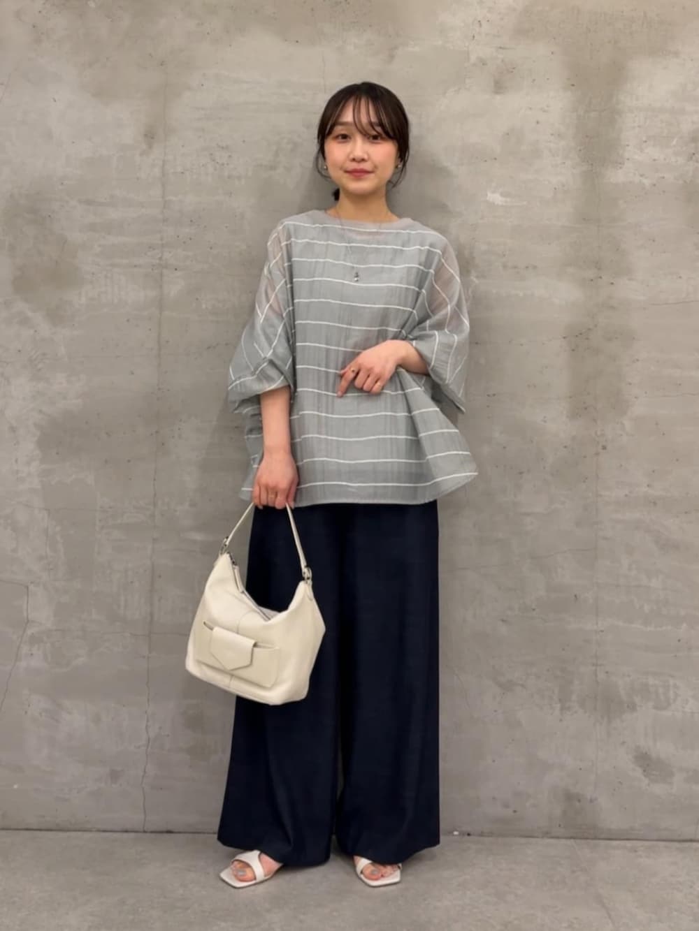 ブルー系のその他パンツ、ホワイト系のトートバッグ、グレー系のシャツ/ブラウスを着用したレディースの春コーディネートの4枚目の写真