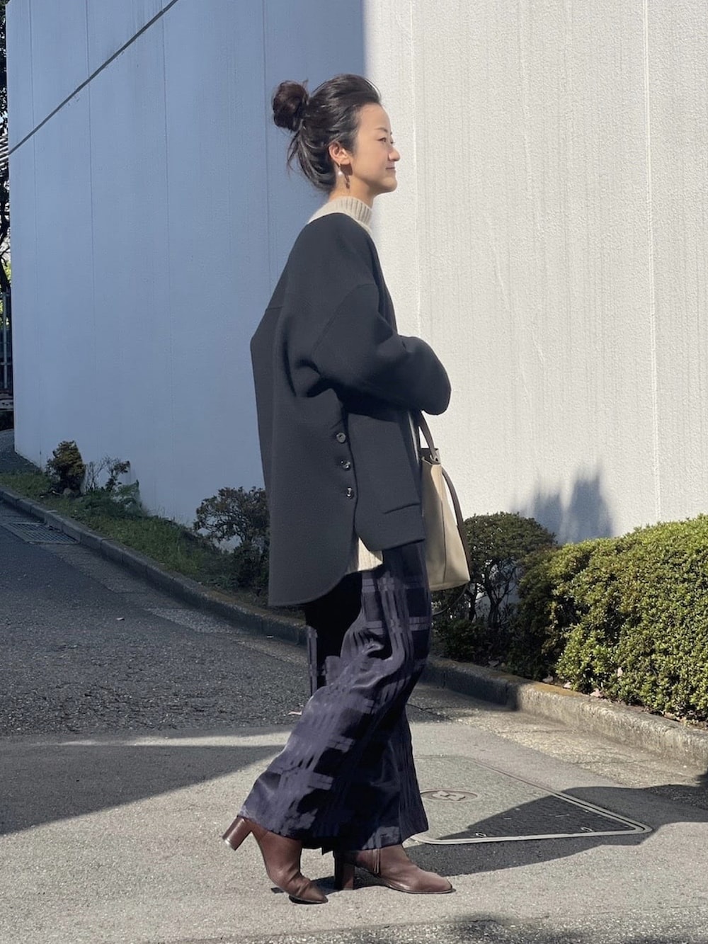 ブルー系のその他パンツ、グリーン系のニット/セーター、ベージュ系のショルダーバッグを着用したレディースの秋コーディネートの2枚目の写真