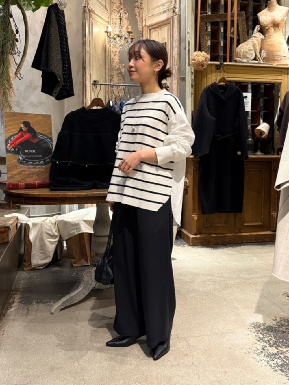 ブラック系のその他パンツ、ホワイト系のニット/セーターを着用したレディースの冬コーディネートの2枚目の写真