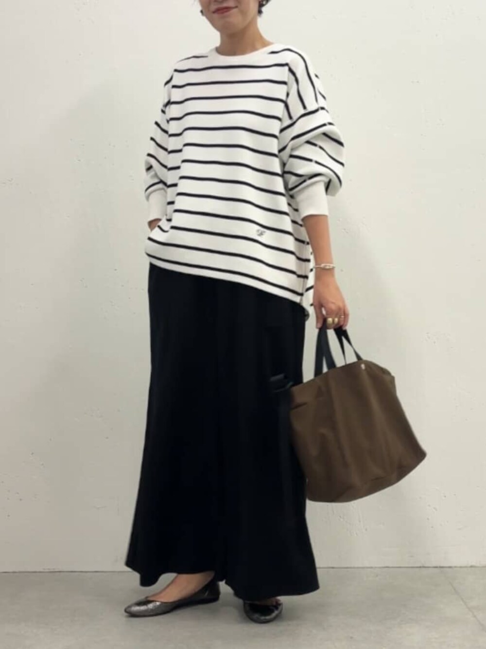 ホワイト系のノーカラージャケット、ブラック系のその他パンツ、ホワイト系のニット/セーターを着用したレディースの冬コーディネートの6枚目の写真