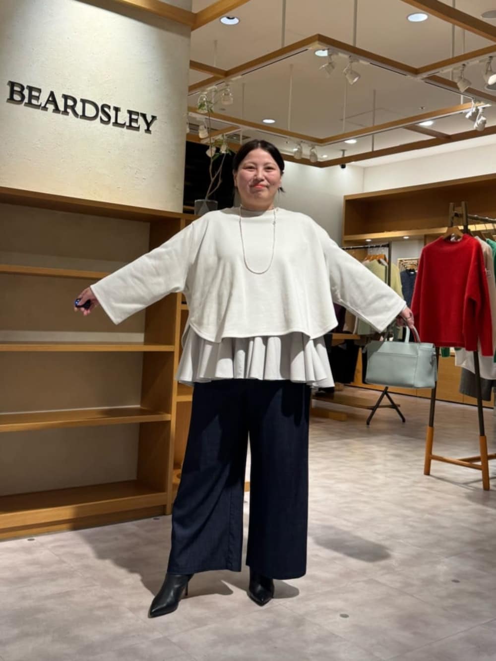 ブルー系のその他パンツ、グリーン系のハンドバッグ、ホワイト系のTシャツ/カットソーを着用したレディースの冬コーディネートの4枚目の写真