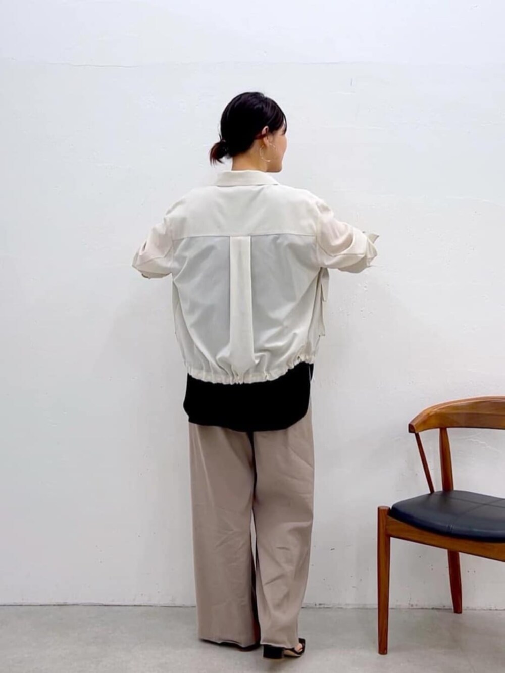 ブラック系のキャミソール、ホワイト系のブルゾン、グレー系のその他パンツを着用したレディースの夏コーディネートの4枚目の写真