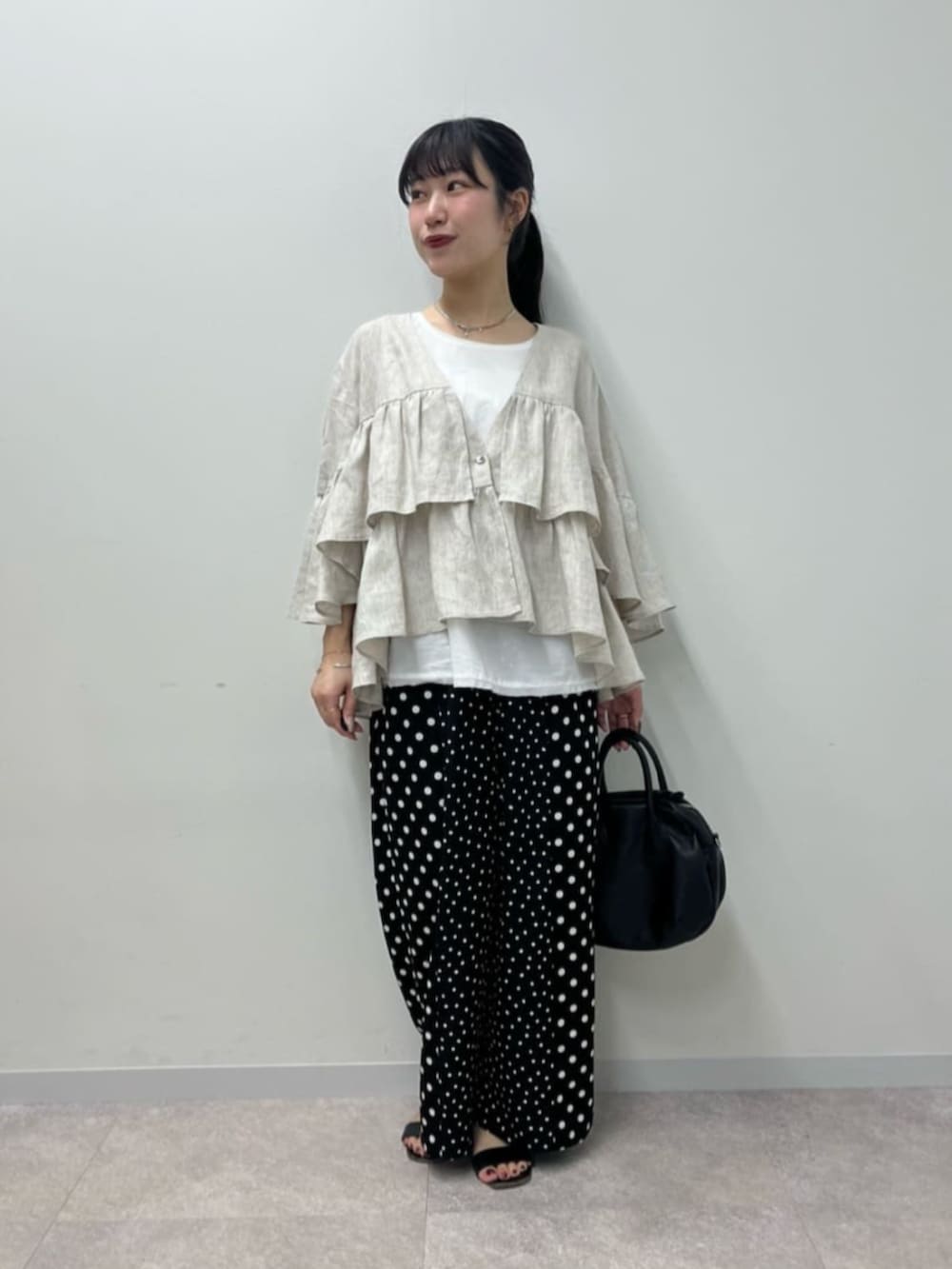 ブラック系のボストンバッグ、ホワイト系のシャツ/ブラウス、ブラック系のその他パンツを着用したレディースの春コーディネートの2枚目の写真