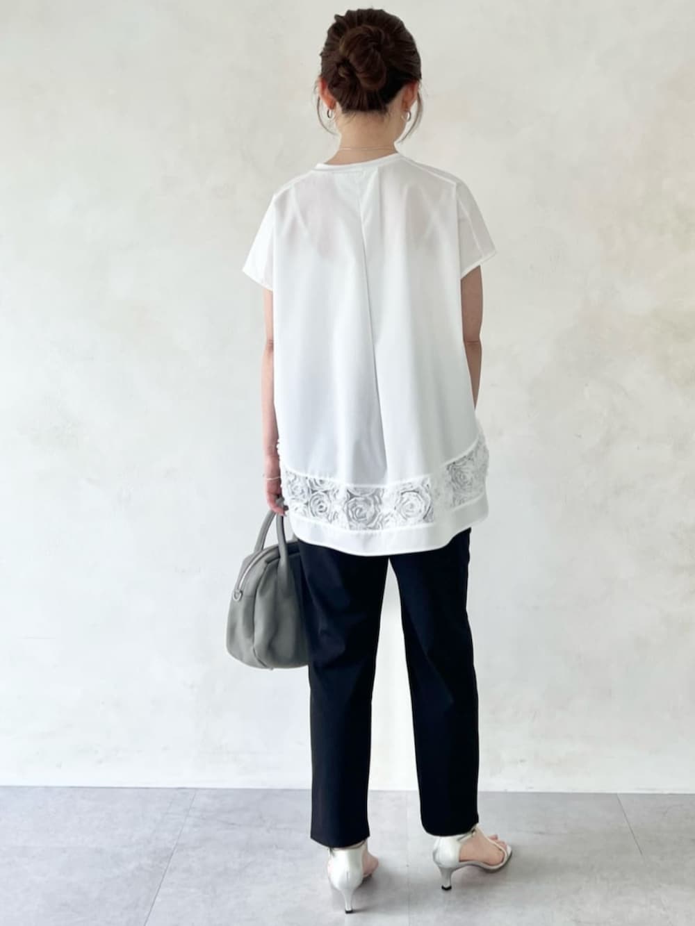 グレー系のボストンバッグ、ホワイト系のTシャツ/カットソーを着用したレディースの春コーディネートの3枚目の写真