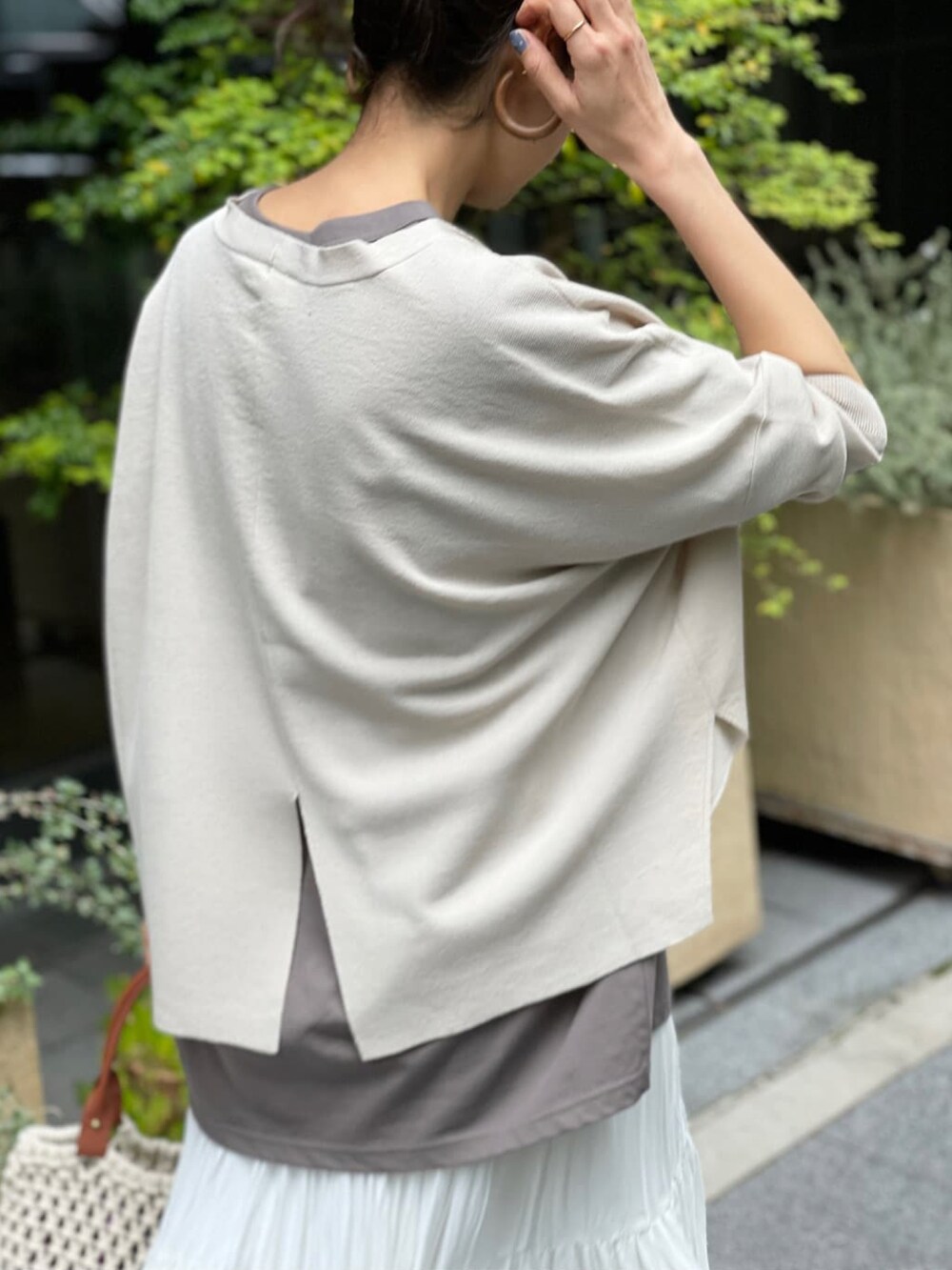 ベージュ系のカーディガン/ボレロ、ブラウン系のTシャツ/カットソー、ホワイト系のスカートを着用したレディースの春コーディネートの3枚目の写真