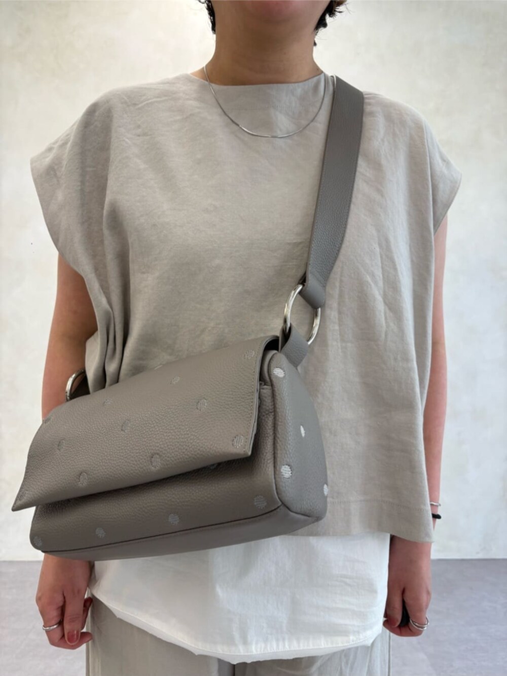 グレー系のショルダーバッグ、ホワイト系のシャツ/ブラウス、グレー系のシャツ/ブラウスを着用したレディースの春コーディネートの4枚目の写真