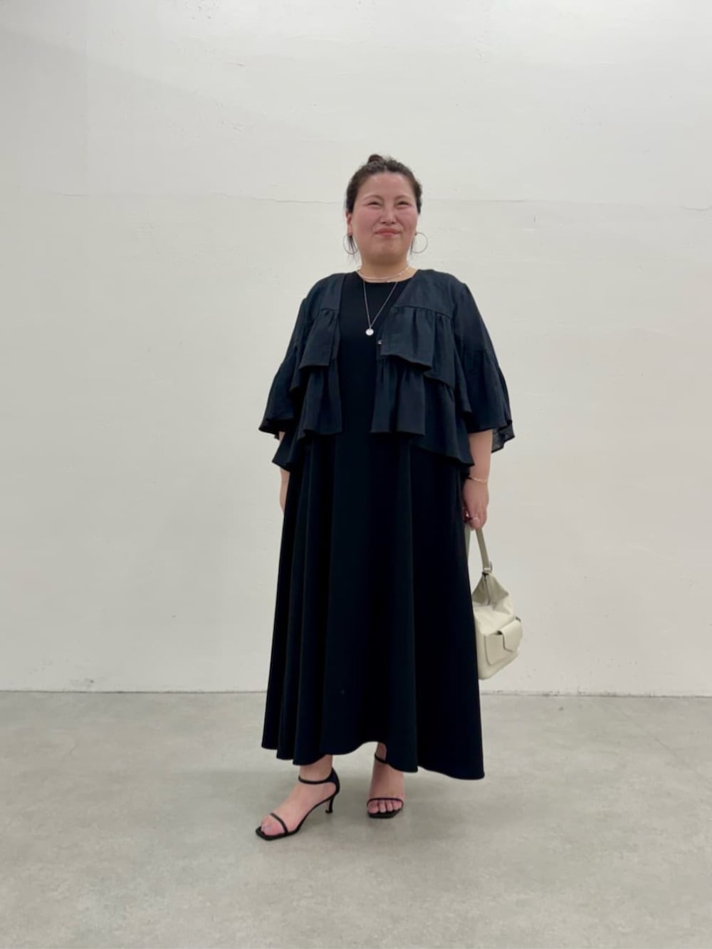 ブラック系のワンピース、ブラック系のその他アウターを着用したレディースの春コーディネートの2枚目の写真