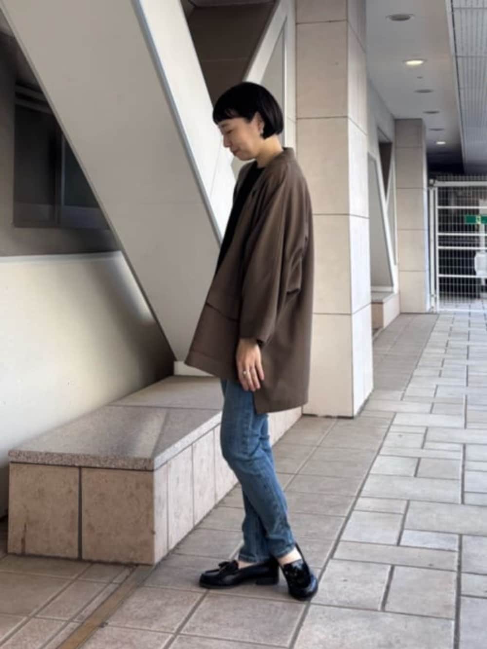 ブルー系のデニムパンツ、ブラウン系のテーラードジャケット、ホワイト系のTシャツ/カットソーを着用したレディースの春コーディネートの3枚目の写真