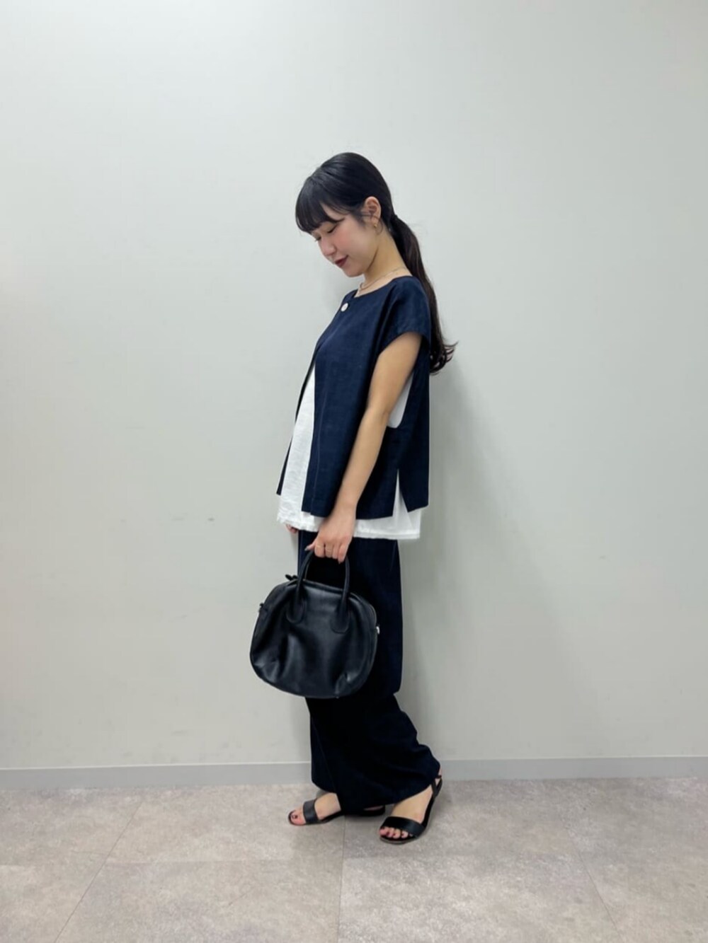 ブルー系のシャツ/ブラウス、ブルー系のその他パンツ、ブラック系のボストンバッグを着用したレディースの春コーディネートの6枚目の写真