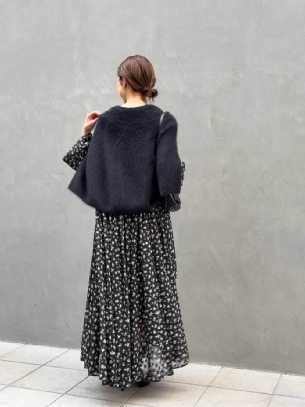 ブラック系のニット/セーター、ブラック系のトートバッグ、ブラック系のワンピースを着用したレディースの夏コーディネートの7枚目の写真