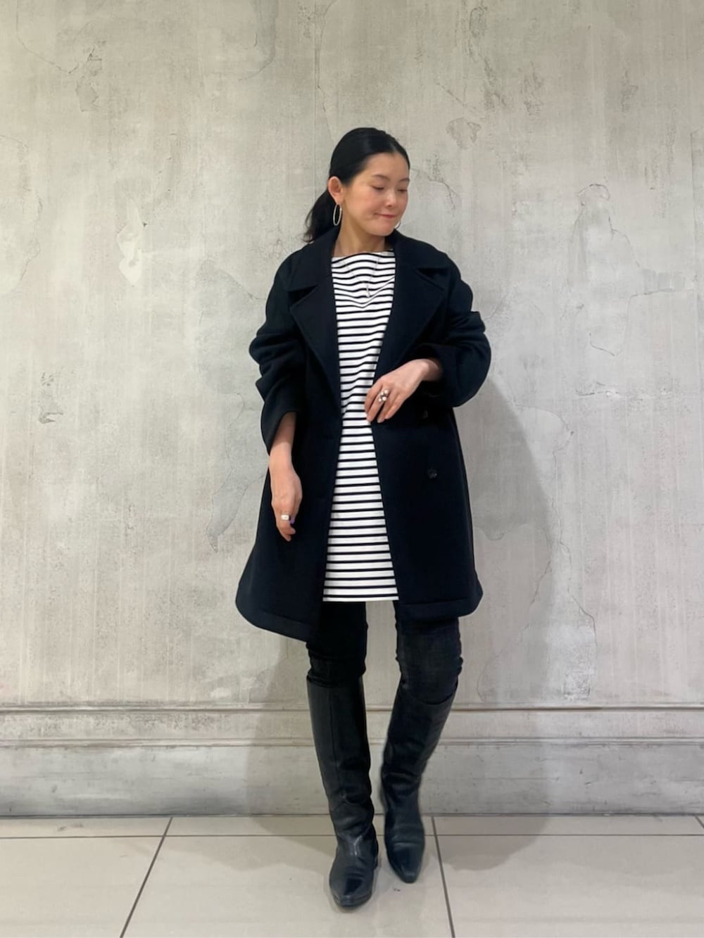 ブルー系のTシャツ/カットソー、ブラック系のデニムパンツ、ブラック系のピーコートを着用したレディースの冬コーディネートの7枚目の写真