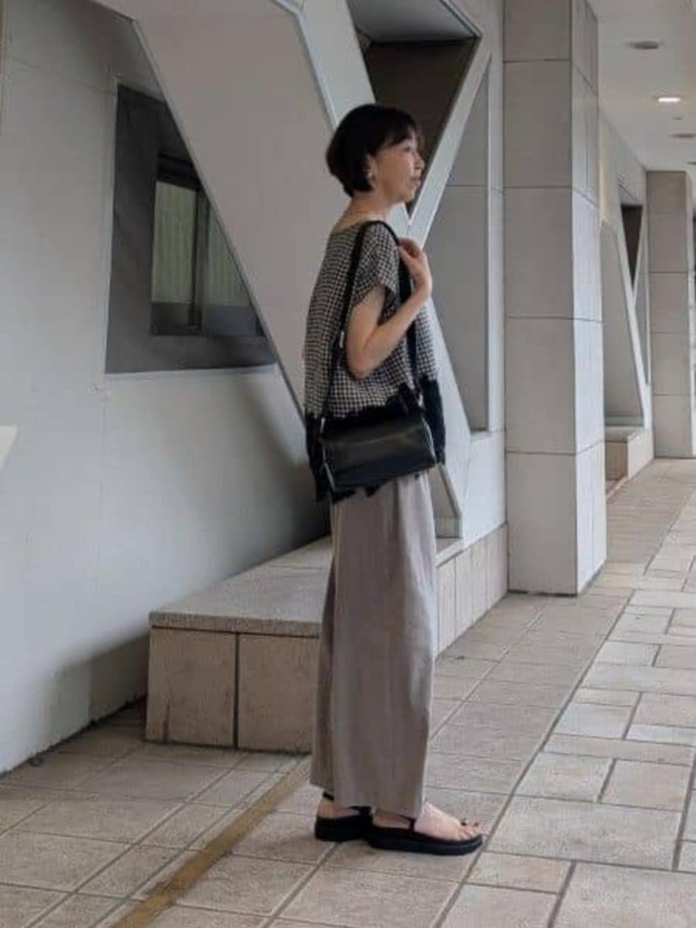 ブラック系のサンダル、ブラック系のシャツ/ブラウス、グレー系のその他パンツを着用したレディースの春コーディネートの2枚目の写真