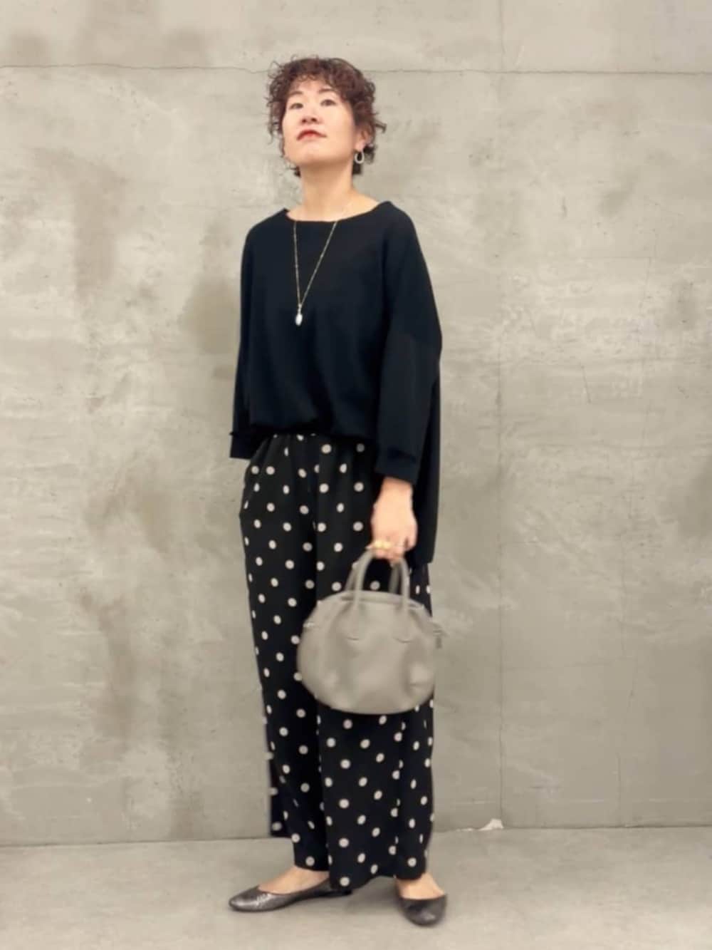 グレー系のボストンバッグ、ブラック系のTシャツ/カットソー、ブラック系のその他パンツを着用したレディースの冬コーディネートの3枚目の写真