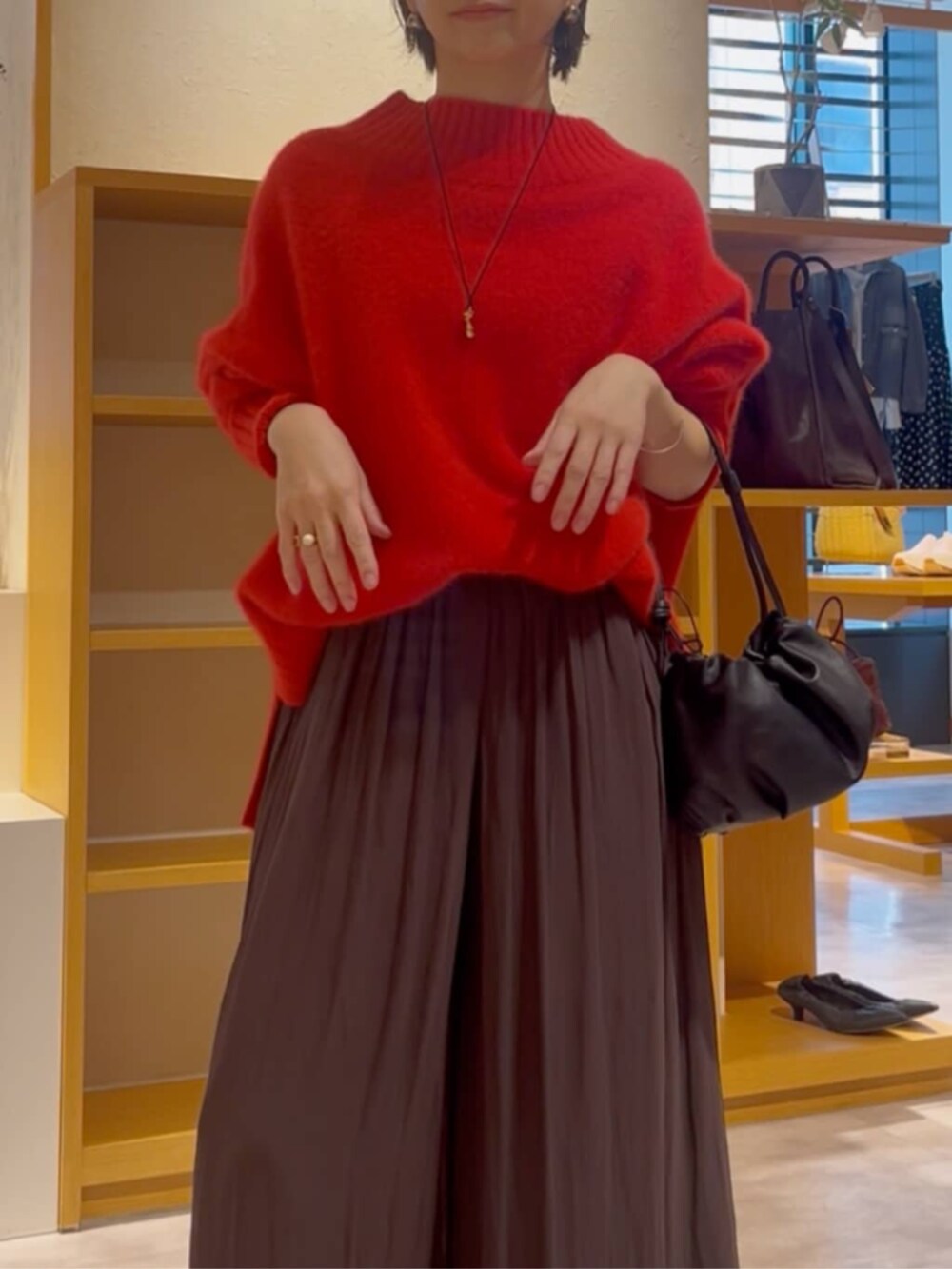 ブラウン系のその他パンツ、ブラック系のノーカラーコート、ブラック系のブーツを着用したレディースの冬コーディネートの8枚目の写真