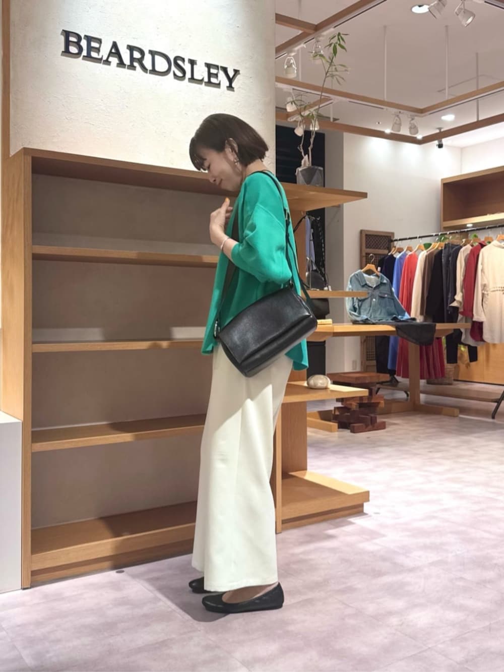 ブラック系のショルダーバッグ、ホワイト系のその他パンツ、グリーン系のTシャツ/カットソーを着用したレディースの春コーディネートの4枚目の写真