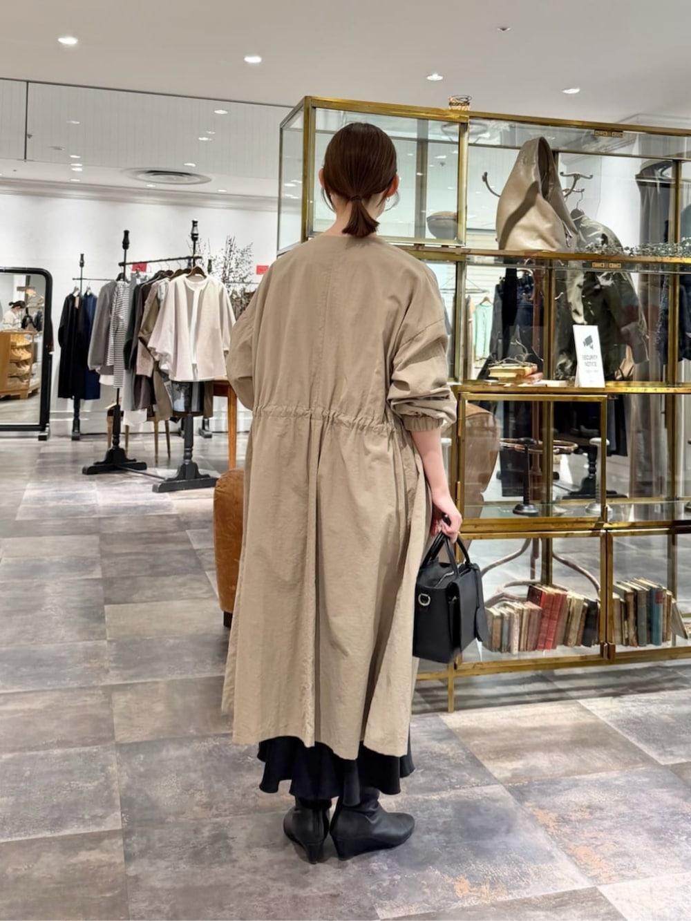 ブラック系のスカート、ベージュ系のその他アウター、ホワイト系のTシャツ/カットソーを着用したレディースの冬コーディネートの3枚目の写真