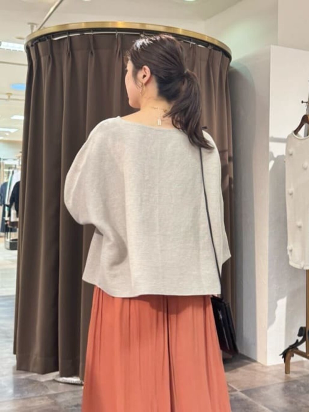 オレンジ系のその他パンツ、ベージュ系のニット/セーターを着用したレディースの春コーディネートの6枚目の写真
